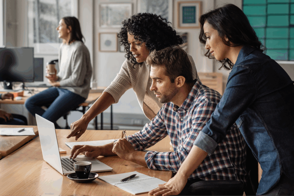 A group of diverse individuals collaborating on a laptop in a modern office setting Custom backpacks 41